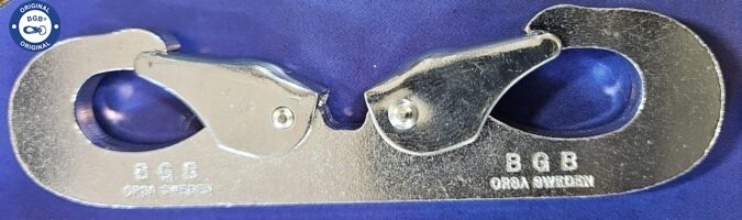 Närbild av en blank dubbel karbinhake i metall med texten ”BGB Orsa Sweden” präglad på den. En "Original BGB"-logotyp är synlig i hörnet.